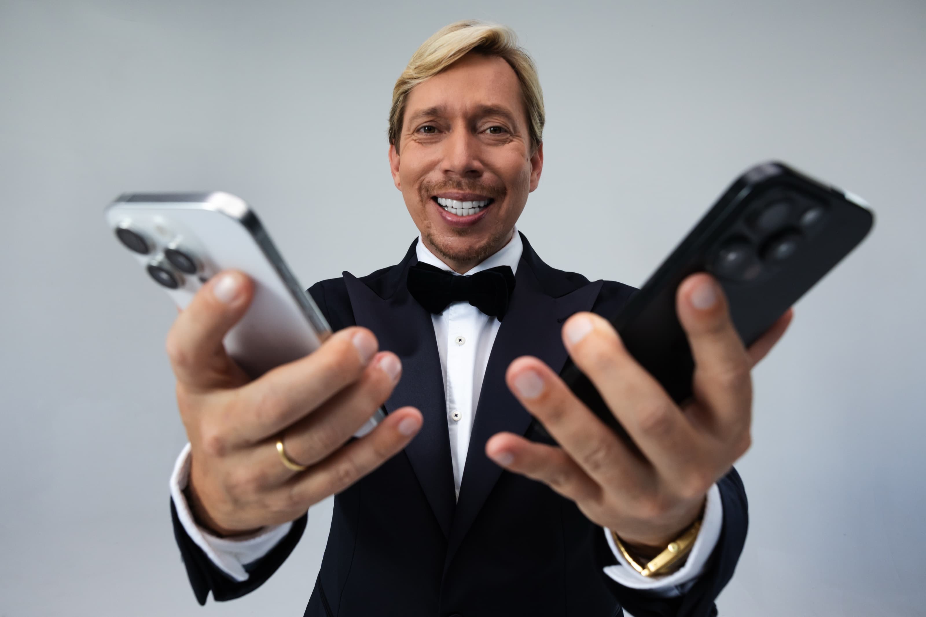 Helmut Werner hält zwei Telefone in die Kamera